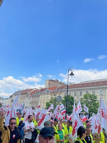 Marsz Solidarności — uczestnicy z flagami Solidarności na ulicy Warszawy